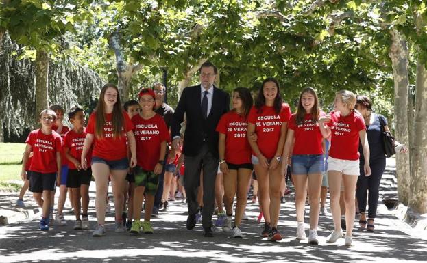 Mariano Rajoy pasea por los jardines de Moncloa junto a los hijos de los empleados del complejo./Diego Crespo (Efe)