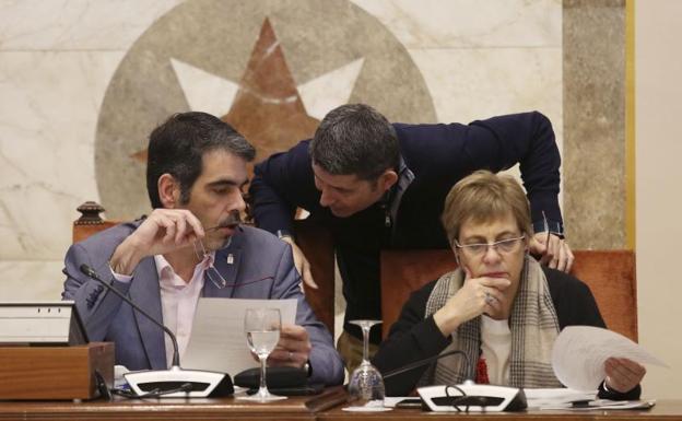 El alcalde, Eneko Goia, habla con el delegado de Urbanismo, Enrique Ramos, en presencia de la concejala Miren Azkarate, ayer en el Pleno del Ayuntamiento/Lusa
