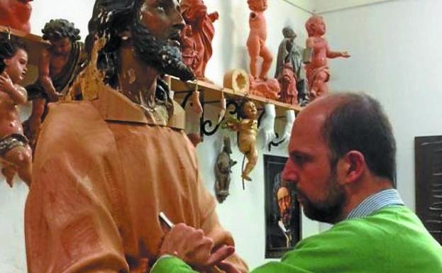 El escultor Alberto Pérez Rojas restaurando la talla de Jesús./