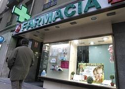 Un hombre camina por delante de una farmacia. / Efe/