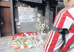 Un hincha del Athletic, ante la ofrenda floral en el lugar donde Iñigo Cabacas cayó desplomado tras darle una pelota de goma. :: BORJA AGUDO/