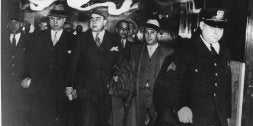 Al Capone, en el centro, rodeado de agentes del FBI, tras ser acusado de evasión de impuestos en 1931. /AP/