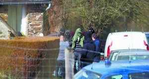 Uno de los presuntos etarras detenidos es llevado por agentes franceses de la casa rural de Cahan en la que se ocultaban a la comisaría de Caen. :: AFP/