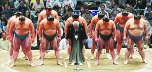 Los luchadores ('rikishi') y su presidente, con kimono, piden perdón a los aficionados por un caso de apuestas fraudulentas destapado en 2010. :: REUTERS/