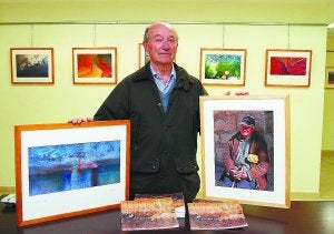 Artista. Luis Laínsa muestra dos de las fotografías de la exposición instalada en Caja Laboral. :: FLOREN PORTU/