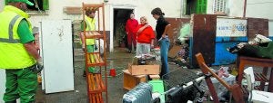 Vecinos del paseo de Antzieta, en Loiola, cuyas calles quedaron completamente inundadas, intentan recuperar parte de sus pertenencias destrozadas tras la riada. :: ARIZMENDI/