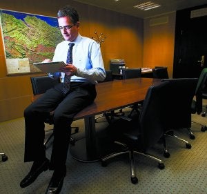 Antonio Basagoiti ojea su tableta digital con un mapa del País Vasco al fondo en un despacho del Grupo Popular en el Parlamento Vasco. :: F. DE LA HERA/