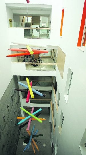 Tres imágenes. La impresionante fachada del colegio, uno de los patios interiores decorado con lápices gigantes y un aula con varios niños. ::
ARIZMENDI/
