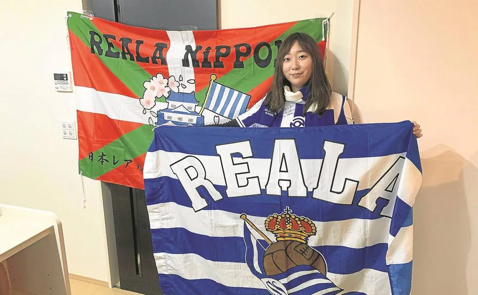 Mio Ortiz posa en su casa de Yokohama con dos banderas de la Real. 