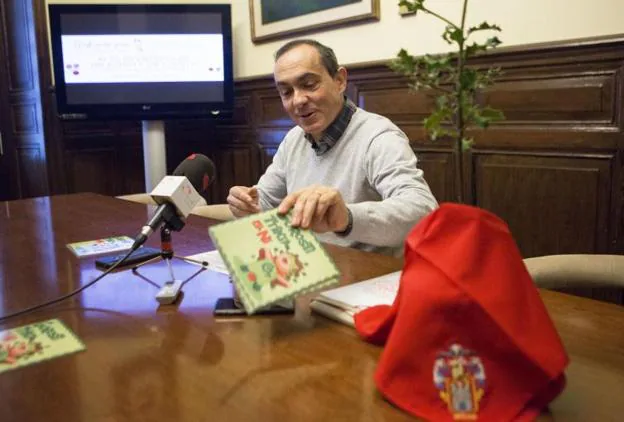 Páez, con ejemplares del cuento, un acebo y el pañuelo que se entrega a los nuevos irundarras. / F. DE LA HERA
