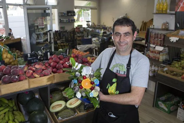 Víctor con uno de sus originales y famosos ramos de frutas que inventó su mujer. / F. DE LA HERA