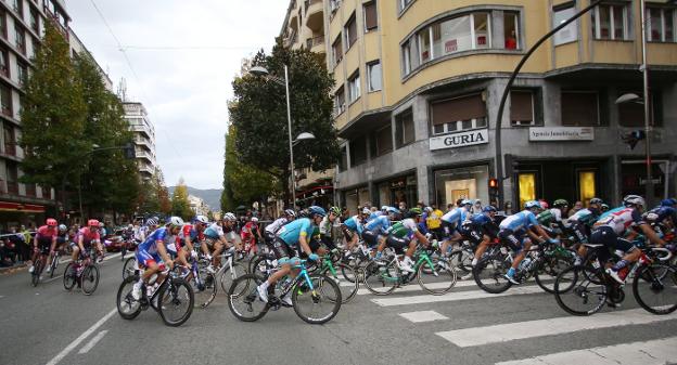 El pelotón de la Vuelta avanza en los primeros metros de la etapa y dobla el paseo Colón de Irun en dirección a la avenida de Iparralde./ F. DE LA HERA