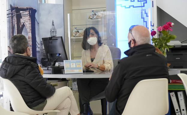 Elena Aguirre atiende a unos clientes en la agencia de viajes.