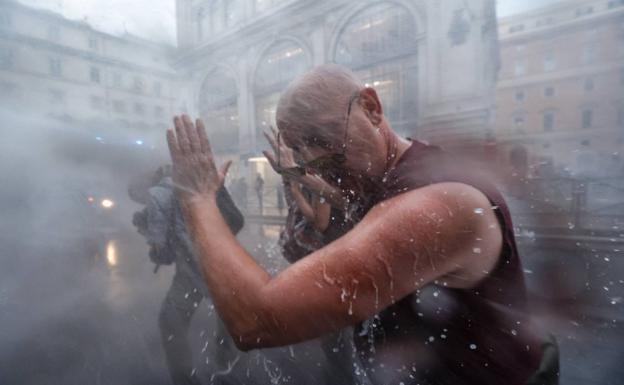 Officers disperse protesters with water cannons during Saturday's protest in Rome. 