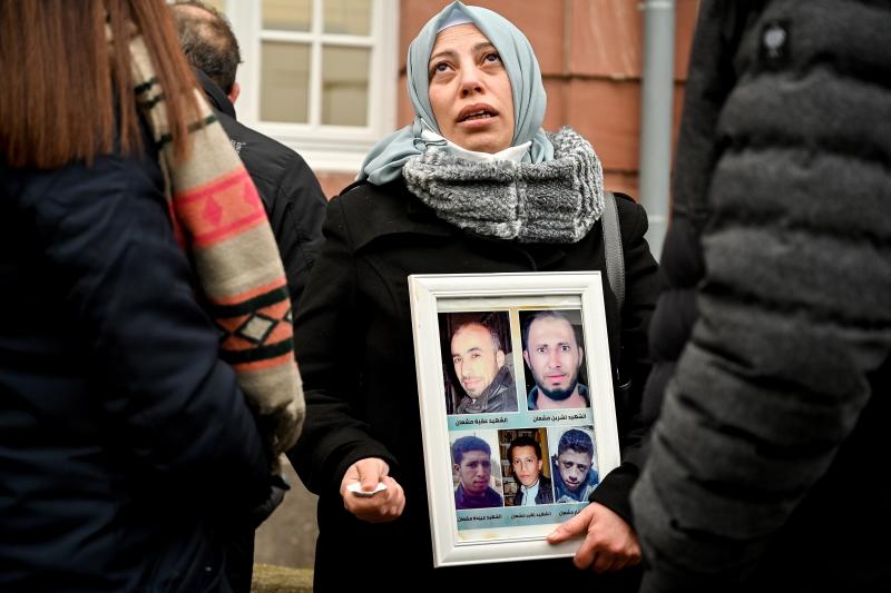 A Syrian refugee displays photos of victims in front of the Koblenz city court. 