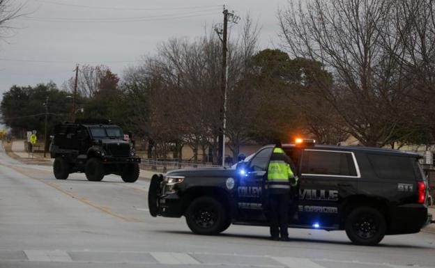 Police vehicles in the area where a man took hostages at a synagogue.