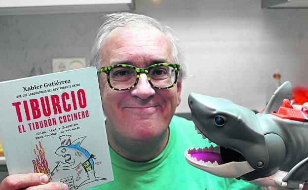 Xabier Gutiérrez posa con su libro y con un 'tiburón' como el personaje Tiburcio, protagonista del volumen. /