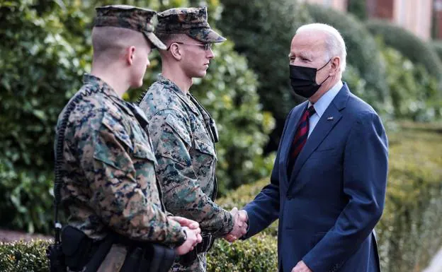 Joe Biden greets two military men. 