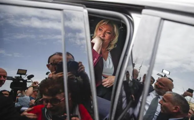 Marine Le Pen enters her vehicle after holding a press conference in Vernon, Normandy.