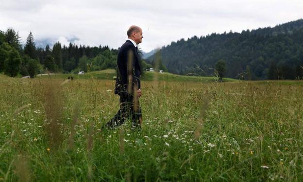 Scholz walks through the fields surrounding Elmau Castle, site of the G7 summit.
