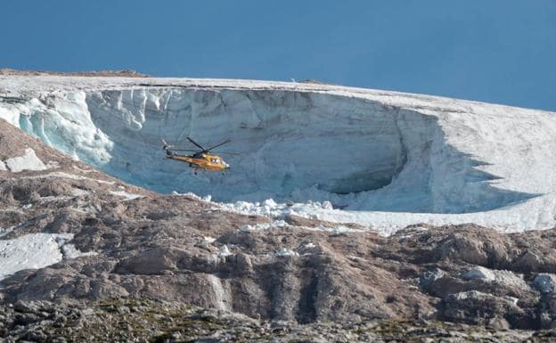 A police helicopter flies over the Marmolada glacier after the accident. 