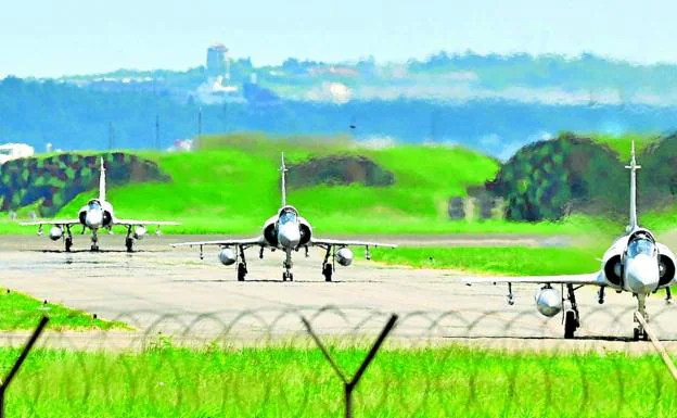 Three fighter jets taxi down a runway at Hsinchu Air Base.