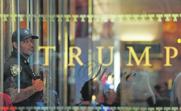 A New York police officer stands guard inside Trump Tower after the FBI entered the former president's summer residence.
