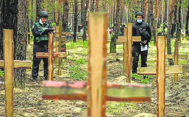 Two police officers analyze the mass grave discovered in Izium, in the Kharkov region. 
