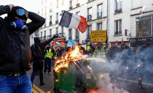 Garbage containers on fire during a protest called this Saturday by youth organizations in Paris.  /Reuters