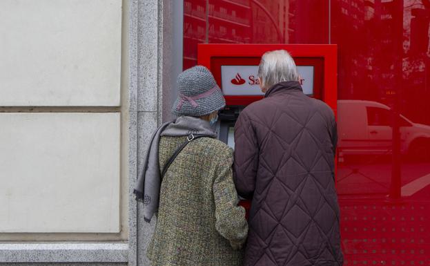 A retired couple use a bank ATM in Madrid. 