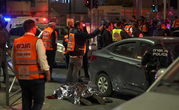 Emergency services cover the body of a victim after the attack on a synagogue. 